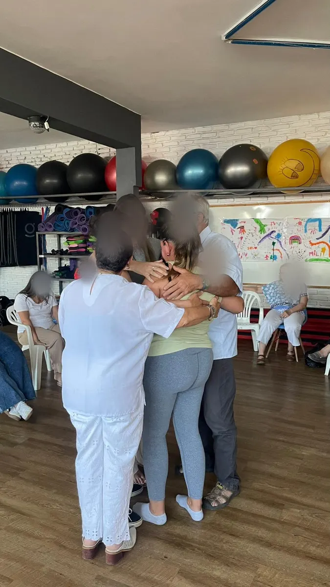 Un grupo de participantes abrazados al cerrar un trabajo.