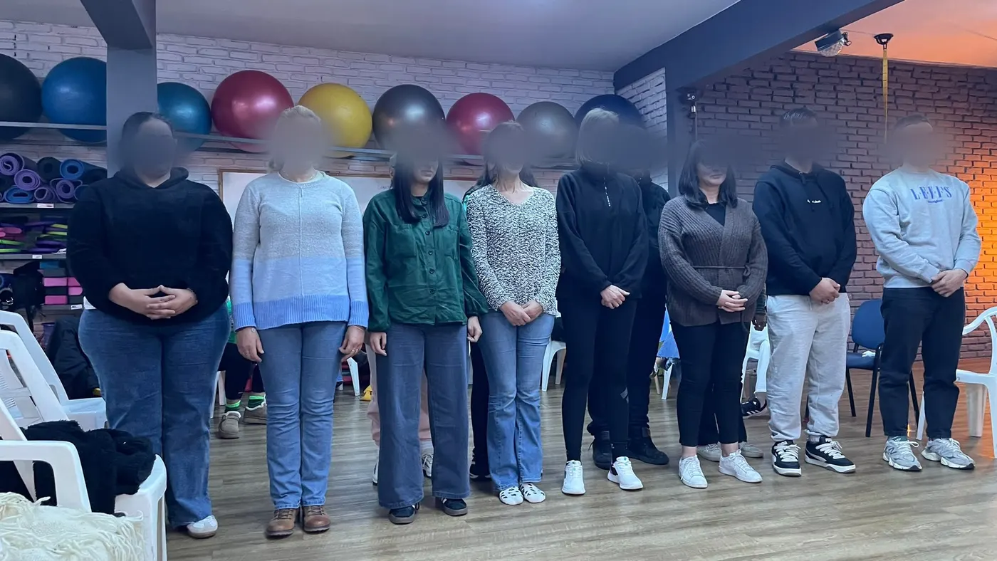 Los participantes de pie, uno al lado del otro, durante un ejercicio.